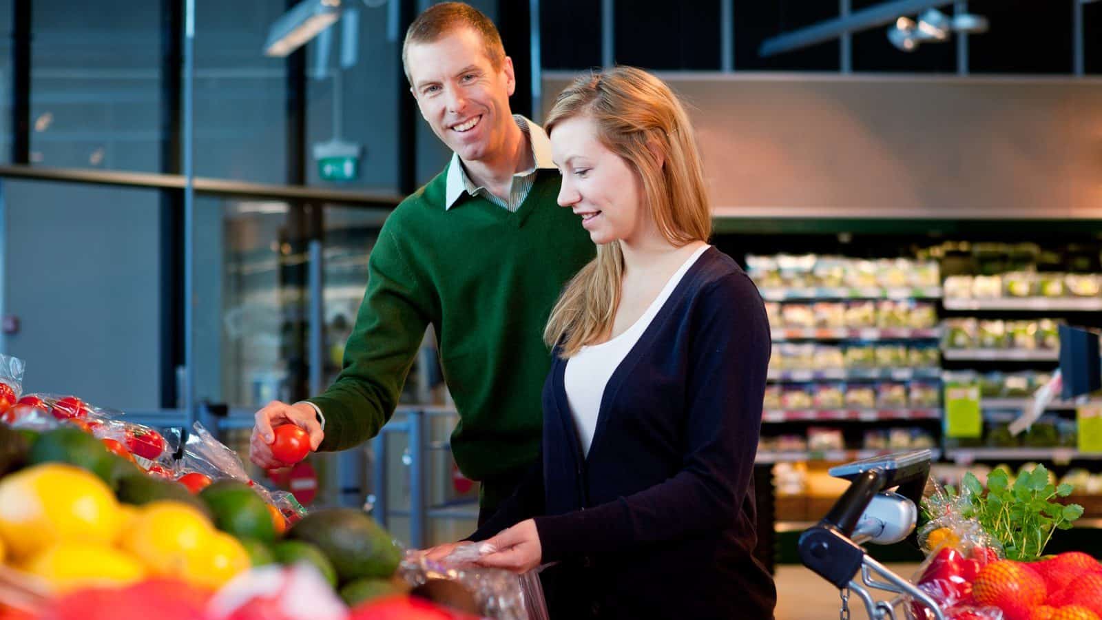 Un couple fait ses course au rayon légume d'un supermarché